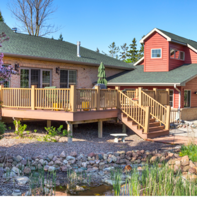 Sunny backyard with deck and blooming tree.