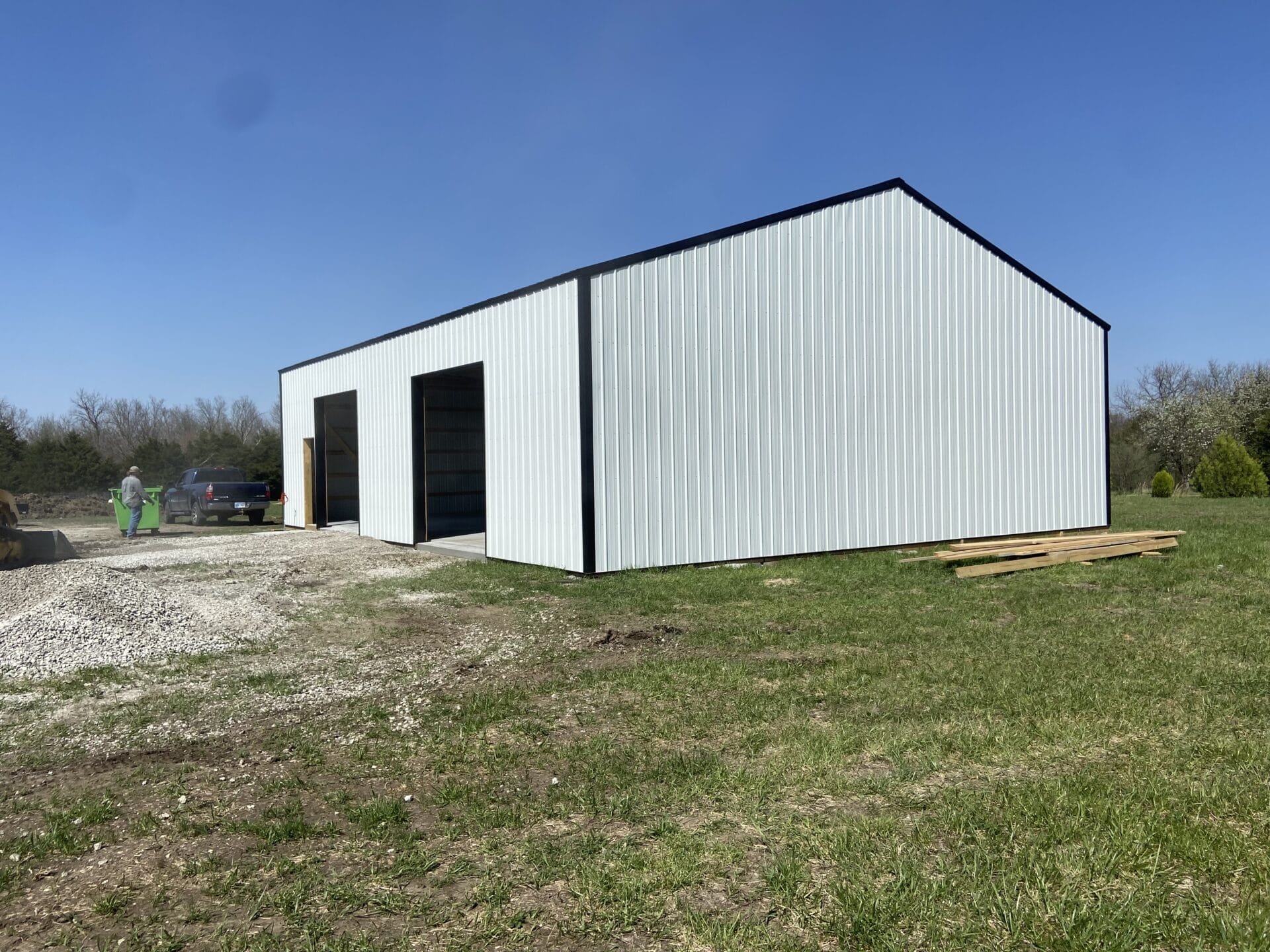 White metal building in grassy area, clear sky